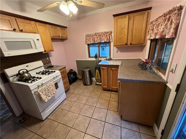 kitchen featuring white appliances, a ceiling fan, brown cabinets, dark countertops, and crown molding