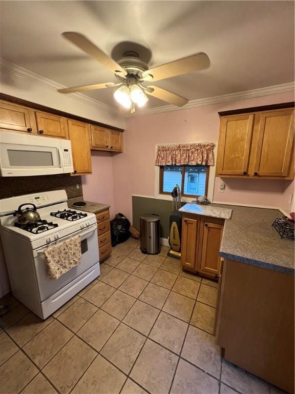 kitchen featuring brown cabinets, crown molding, dark countertops, a ceiling fan, and white appliances