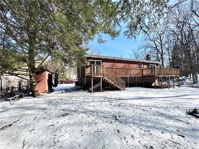 snow covered house with a deck and stairs