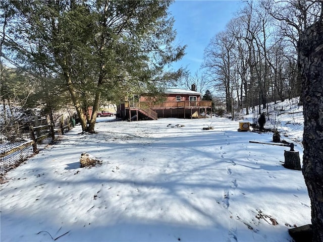 yard layered in snow with stairway and a wooden deck