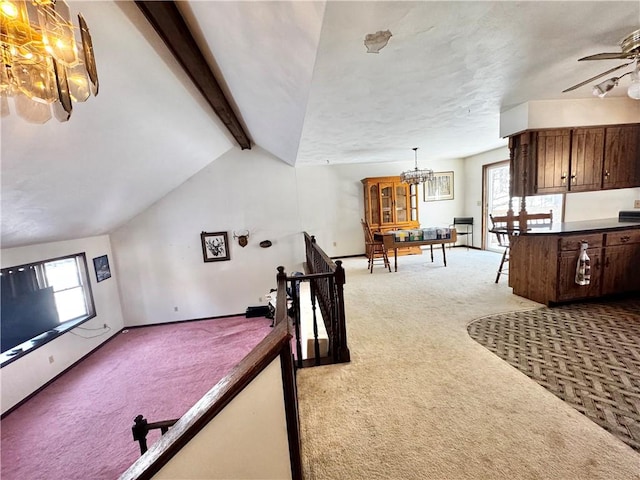 rec room with vaulted ceiling with beams, baseboards, ceiling fan with notable chandelier, and light colored carpet