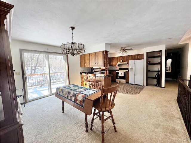 dining room featuring ceiling fan with notable chandelier and light colored carpet