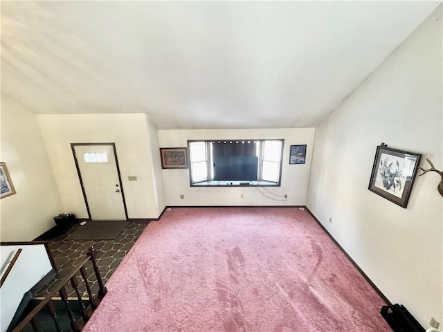 unfurnished living room with lofted ceiling and dark carpet