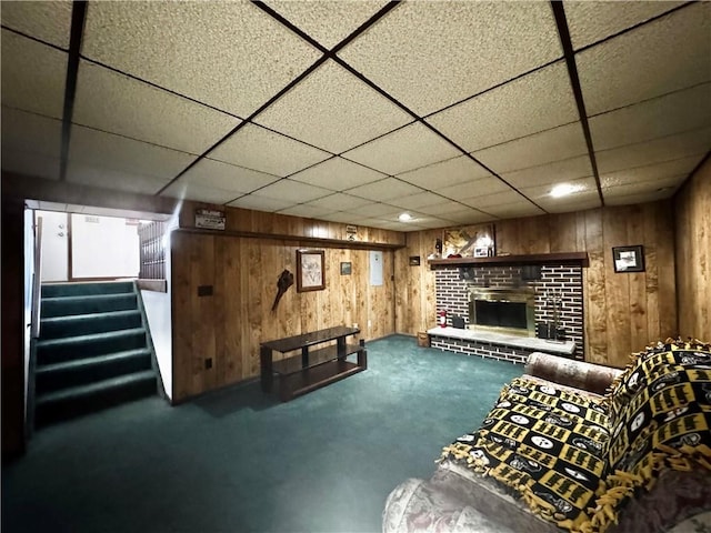 living area with carpet, a brick fireplace, wood walls, and stairway