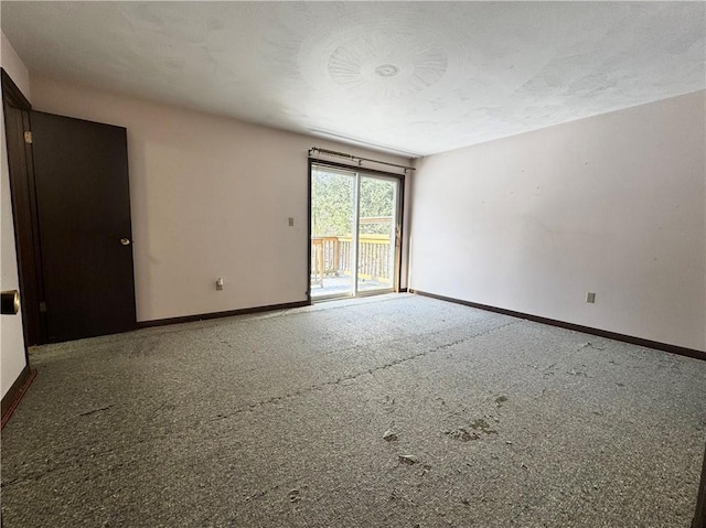 empty room with carpet and baseboards