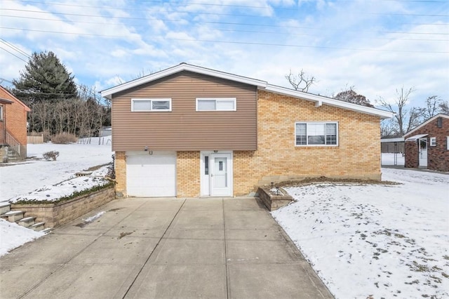 view of front of house featuring an attached garage, driveway, and brick siding