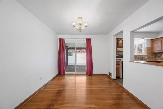 interior space with an inviting chandelier, plenty of natural light, visible vents, and dark wood finished floors