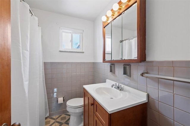 full bath featuring wainscoting, toilet, tile walls, and vanity