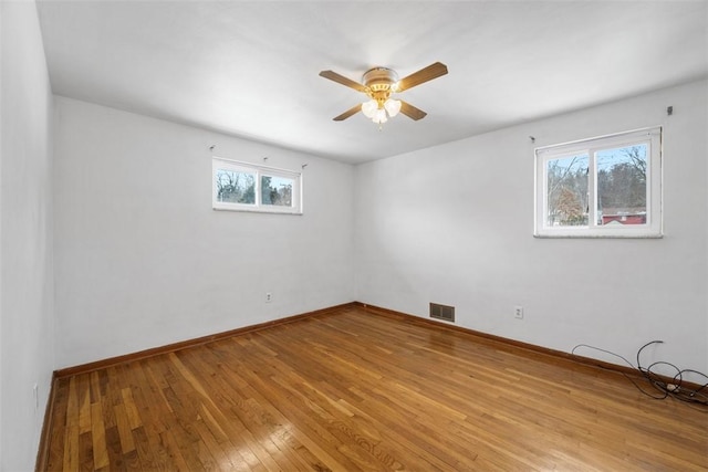 empty room with light wood-type flooring, baseboards, visible vents, and ceiling fan