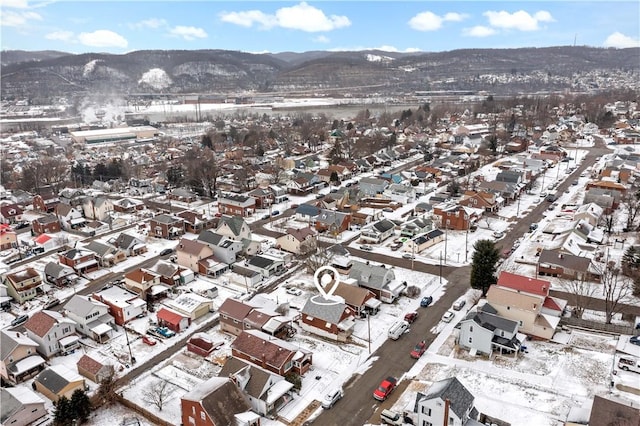 snowy aerial view featuring a residential view and a mountain view