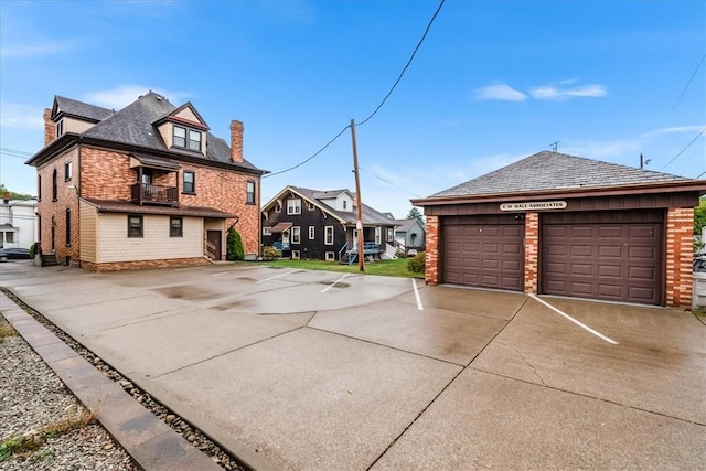 view of home's exterior with a garage, a residential view, brick siding, and a chimney