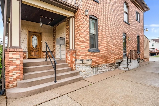 doorway to property with brick siding