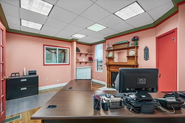 office with crown molding, a paneled ceiling, visible vents, wood finished floors, and baseboards