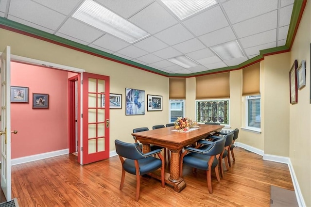 dining room featuring a paneled ceiling, visible vents, baseboards, french doors, and light wood finished floors