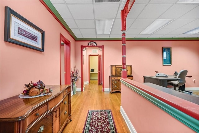 interior space with a paneled ceiling, light wood finished floors, visible vents, and baseboards