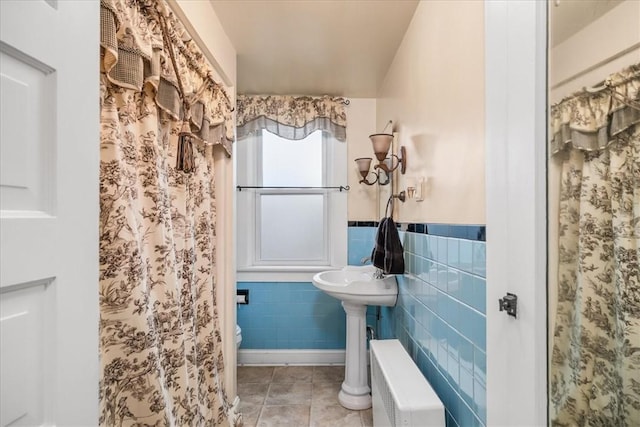 full bath featuring wainscoting, toilet, radiator heating unit, tile patterned floors, and tile walls