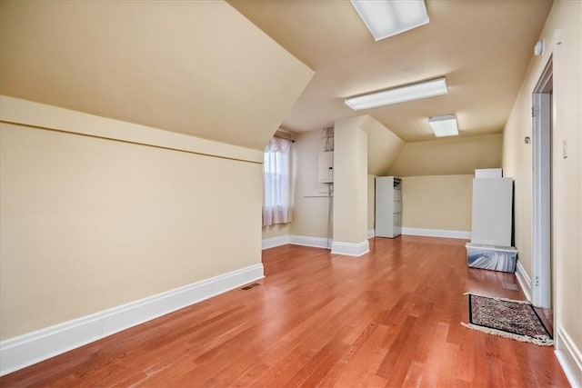 bonus room featuring vaulted ceiling, light wood finished floors, visible vents, and baseboards