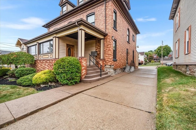 view of front facade featuring brick siding and a front lawn