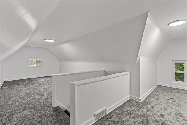 bonus room with lofted ceiling, baseboards, visible vents, and dark colored carpet