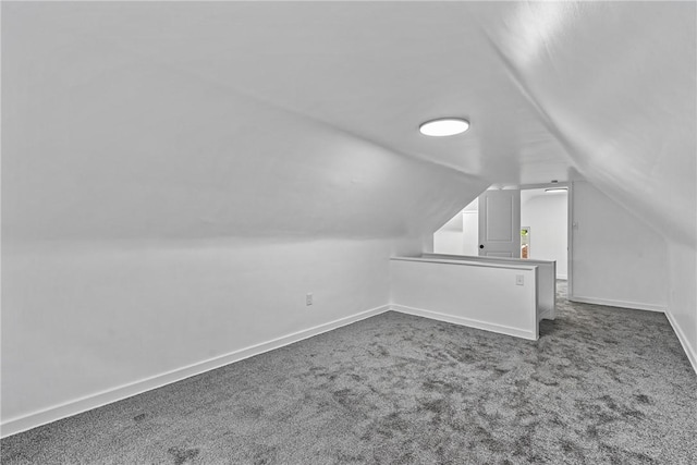 additional living space with vaulted ceiling, carpet, and baseboards