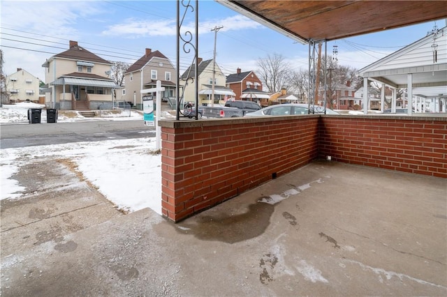 snow covered patio with a residential view