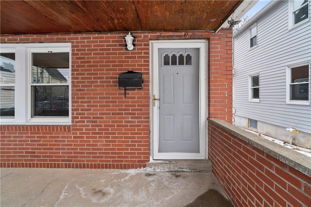 view of exterior entry featuring brick siding