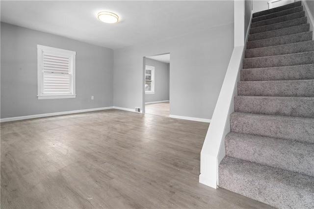 interior space with visible vents, stairway, baseboards, and wood finished floors