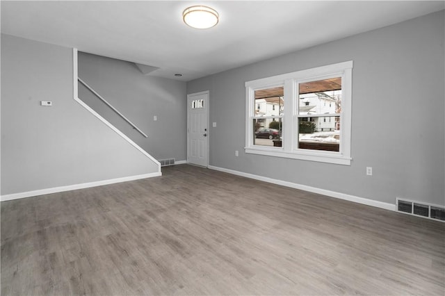 foyer featuring dark wood-type flooring, visible vents, and baseboards