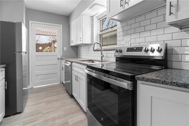 kitchen featuring a wealth of natural light, appliances with stainless steel finishes, a sink, and white cabinetry