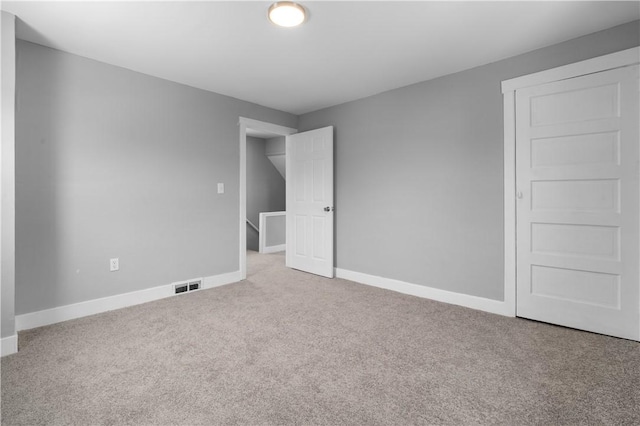 unfurnished bedroom with carpet floors, visible vents, and baseboards