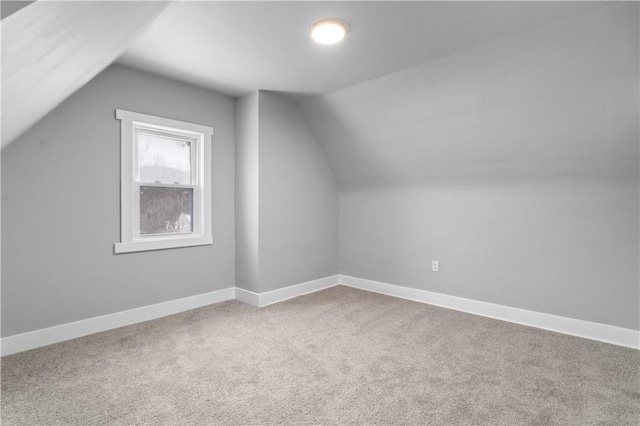 bonus room with vaulted ceiling, carpet floors, and baseboards