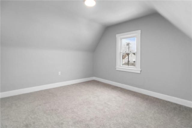 additional living space with vaulted ceiling, carpet floors, and baseboards