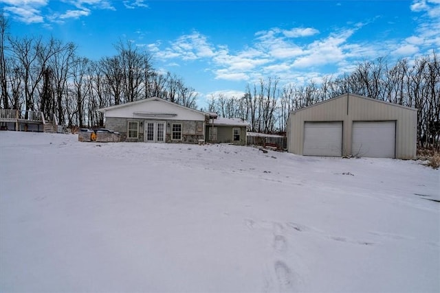 exterior space featuring a garage, french doors, and an outdoor structure