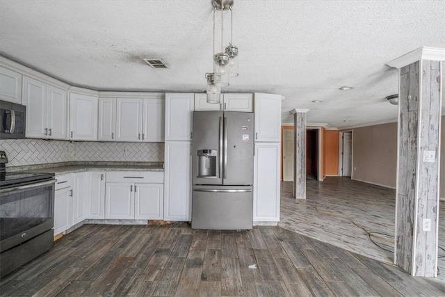 kitchen featuring appliances with stainless steel finishes, pendant lighting, white cabinetry, and dark wood-style flooring