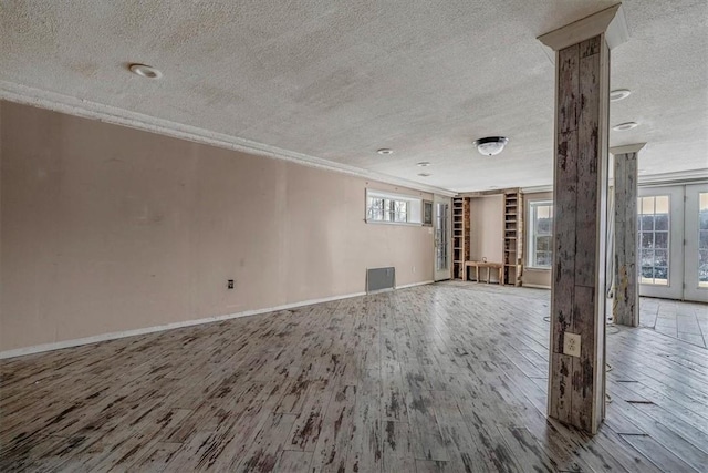 unfurnished living room featuring ornamental molding, wood finished floors, and visible vents