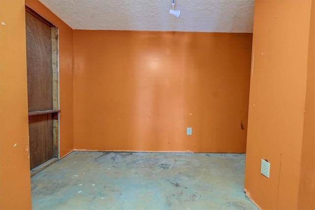 spare room with concrete flooring and a textured ceiling