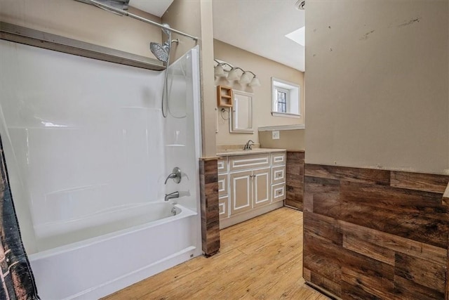 bathroom with shower / bathtub combination, a skylight, wood finished floors, and vanity