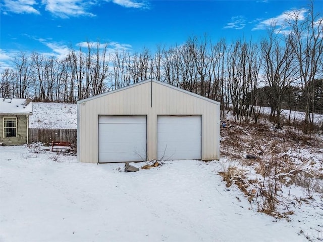 snow covered garage featuring a detached garage