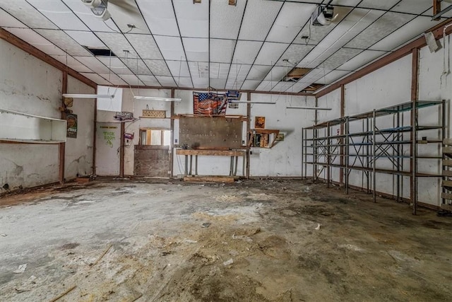 miscellaneous room featuring a drop ceiling and unfinished concrete floors