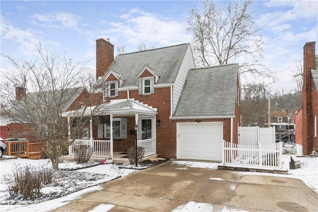 view of front of home with a garage, brick siding, concrete driveway, roof with shingles, and a chimney