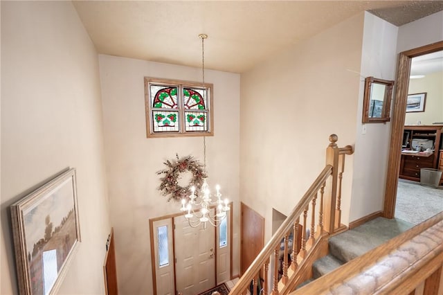 stairway with carpet, a notable chandelier, and baseboards