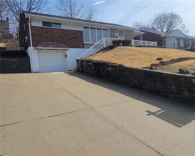 single story home with a garage, concrete driveway, and brick siding