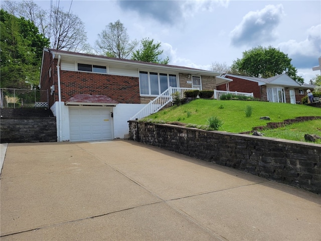 ranch-style home featuring brick siding, driveway, a front yard, and an attached garage