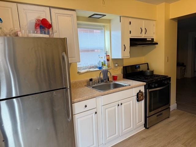 754 N Sheridan Ave, Highland Park, PA 15206 - kitchen with stainless steel appliances, under cabinet range hood, light wood-type flooring, white cabinets, and light countertops