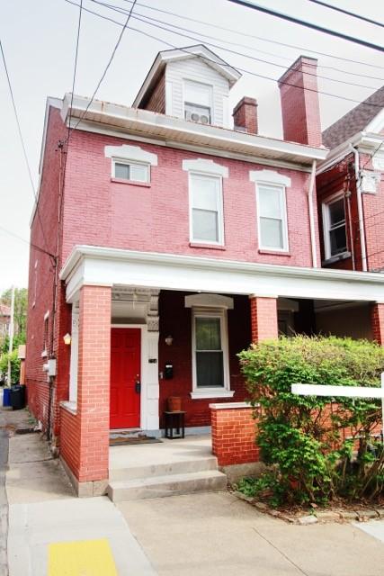 754 N Sheridan Ave, Highland Park, PA 15206 - view of property featuring brick siding, a porch, and a chimney