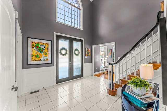 foyer with visible vents, a healthy amount of sunlight, french doors, and stairway