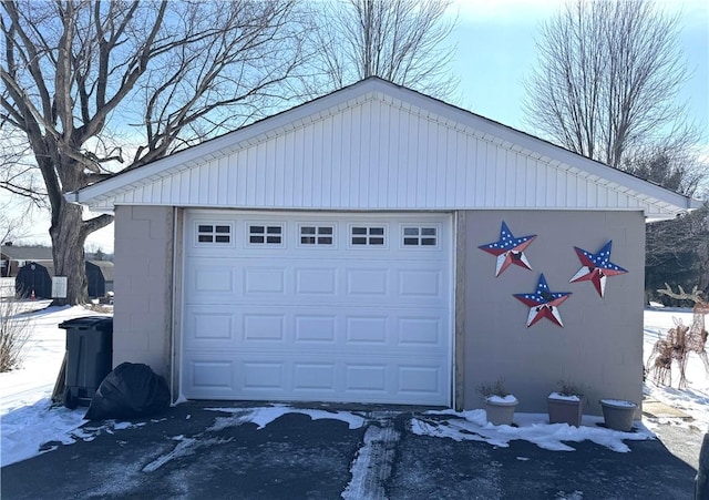 snow covered garage with a garage