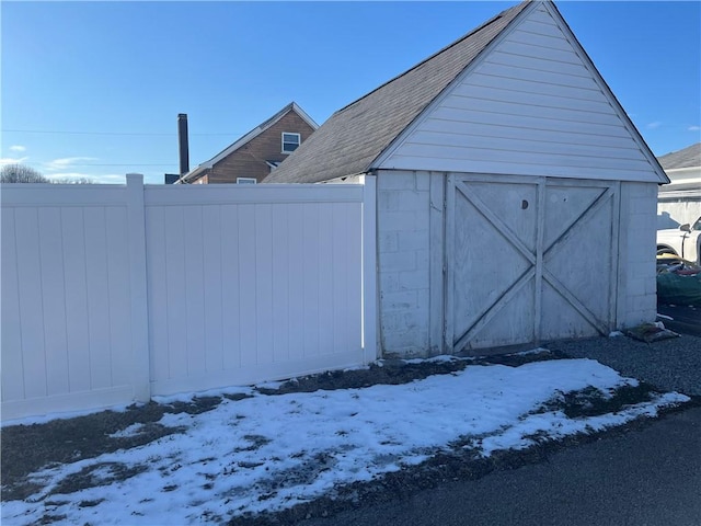 snow covered structure featuring fence