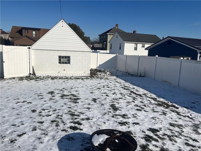 yard layered in snow featuring a fire pit and a fenced backyard