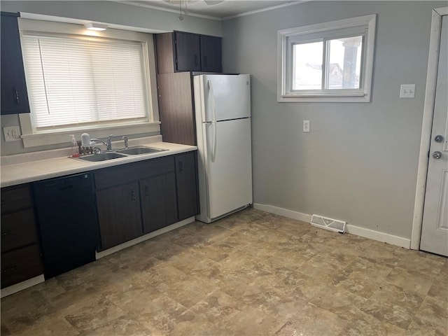 kitchen with visible vents, dishwasher, freestanding refrigerator, light countertops, and a sink